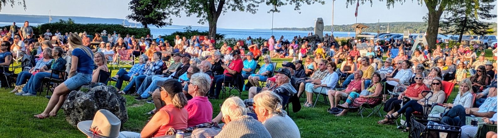 People watching an outdoor concert by the bay